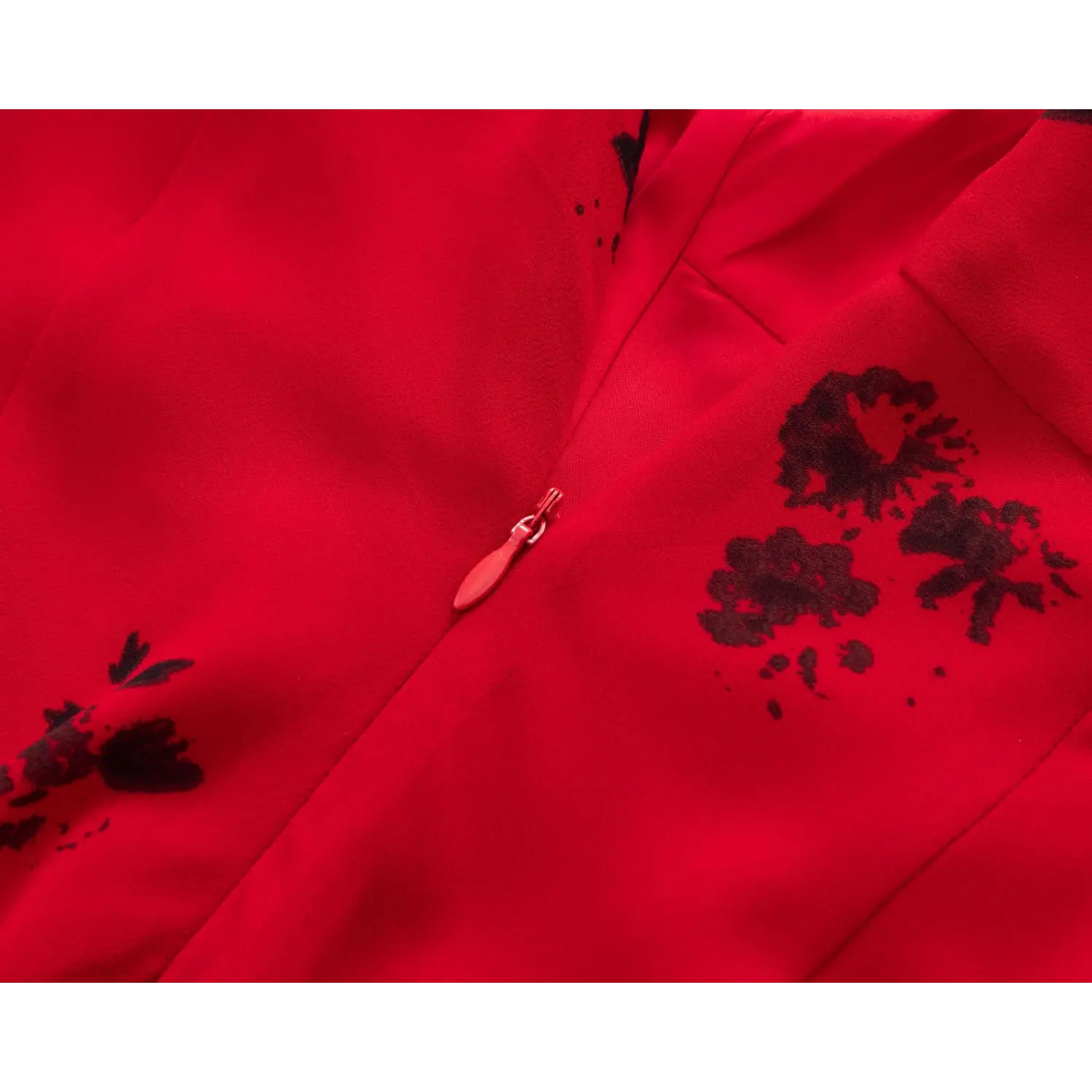 Close‑up of invisible zipper at back seam, red chiffon fabric with scattered black floral pattern