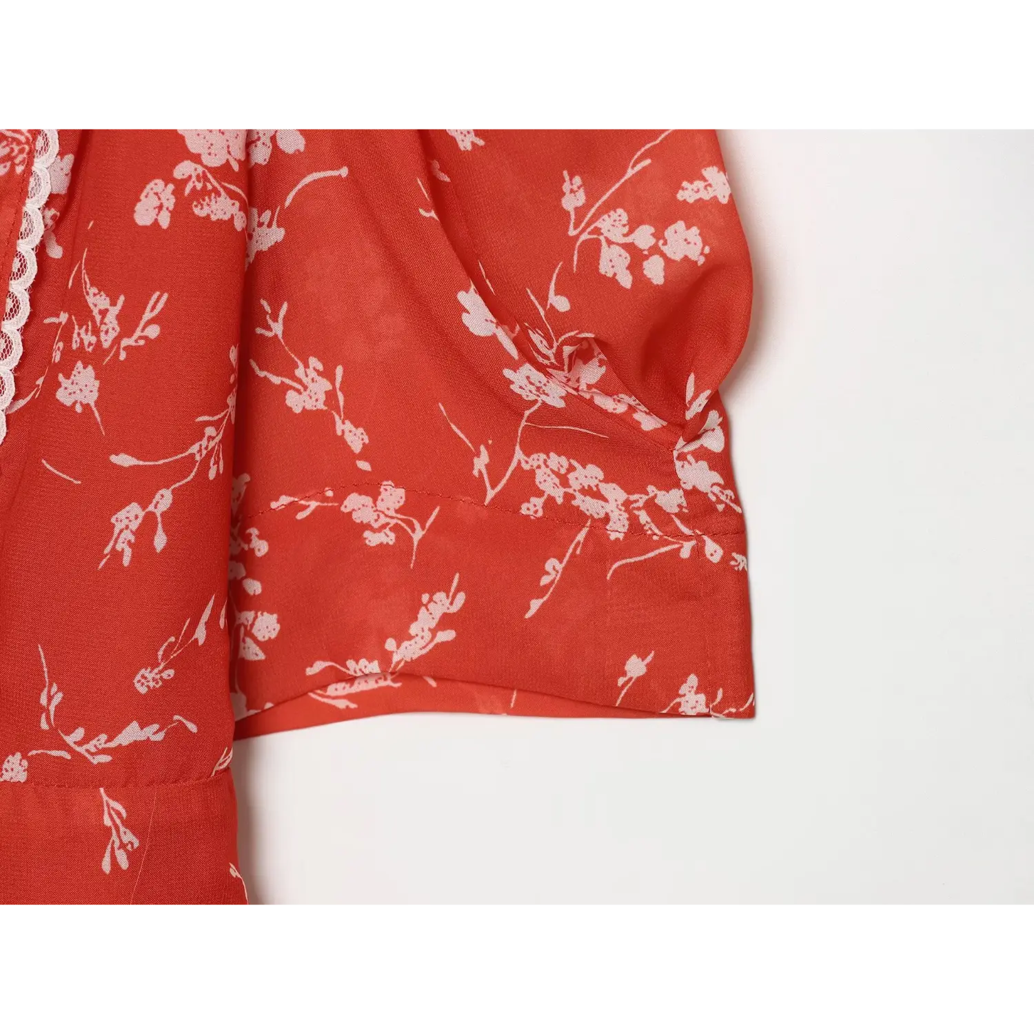 Close-up of puff elbow sleeve cuff construction on red blossom print chiffon mini dress