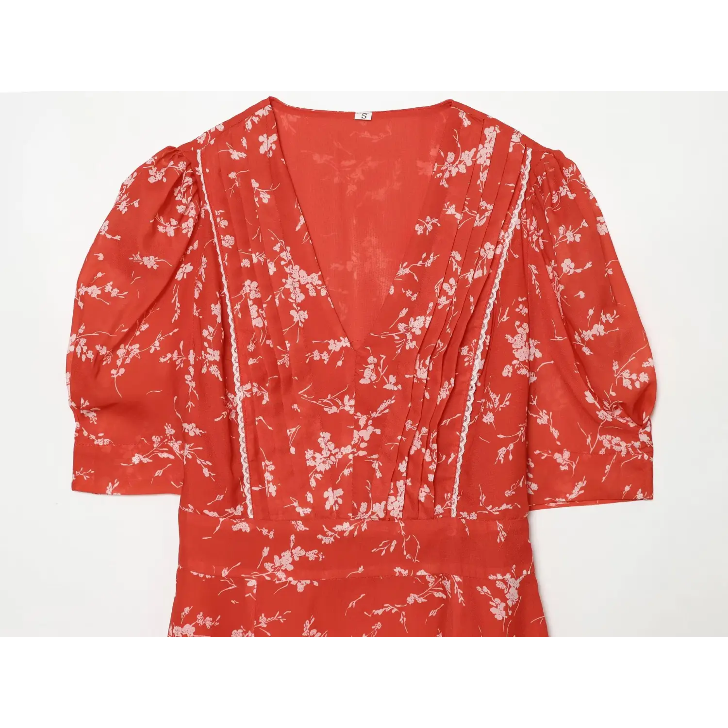 Close-up of V-neck pleated bodice with white lace piping on red floral chiffon mini dress