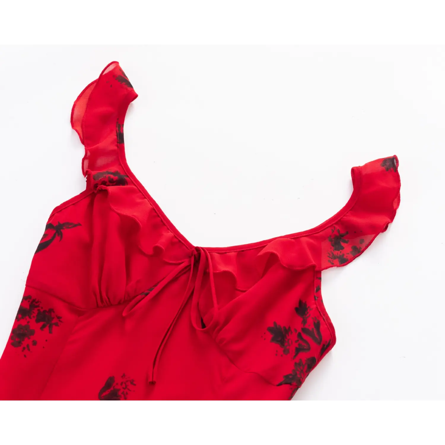 Close‑up of v‑neckline, ruffle cami shoulder straps and front tie on red black floral chiffon mini dress
