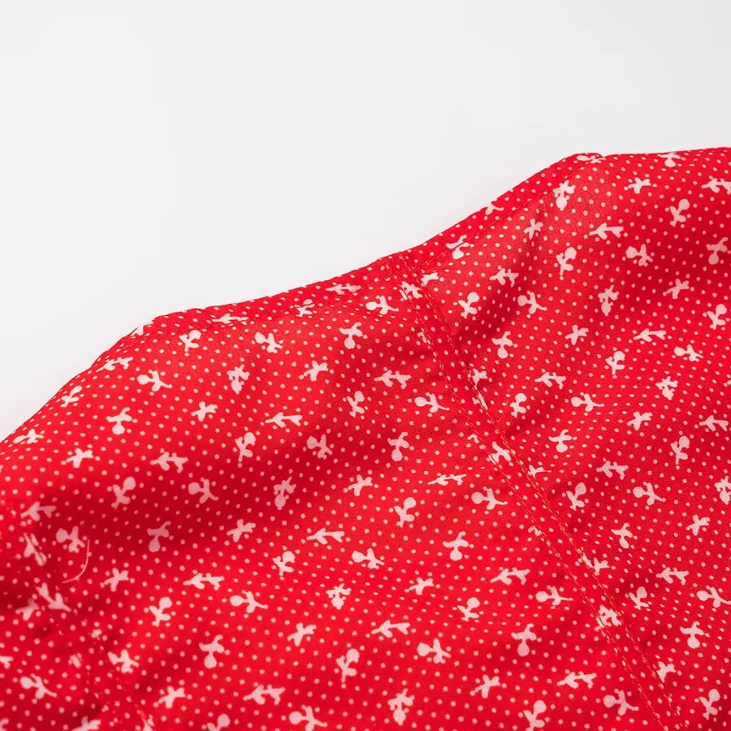 Macro view of red ditsy floral fabric and garment stitching seam