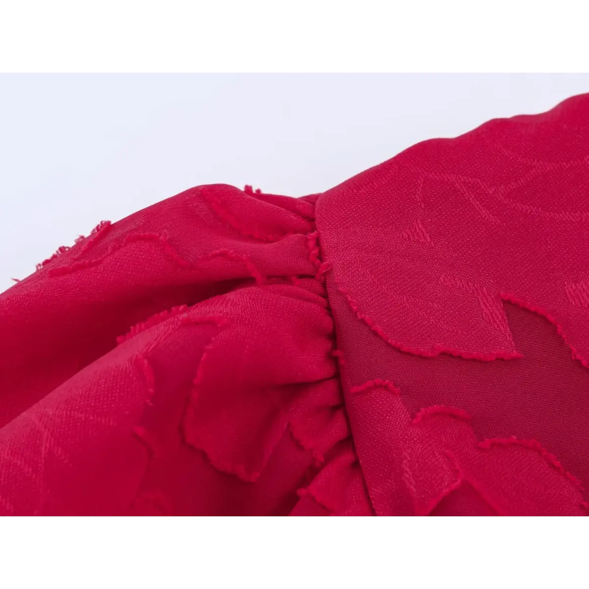 Macro close-up of the gathered puff sleeve texture on a red floral appliqu peplum top, highlighting the fabric weave.