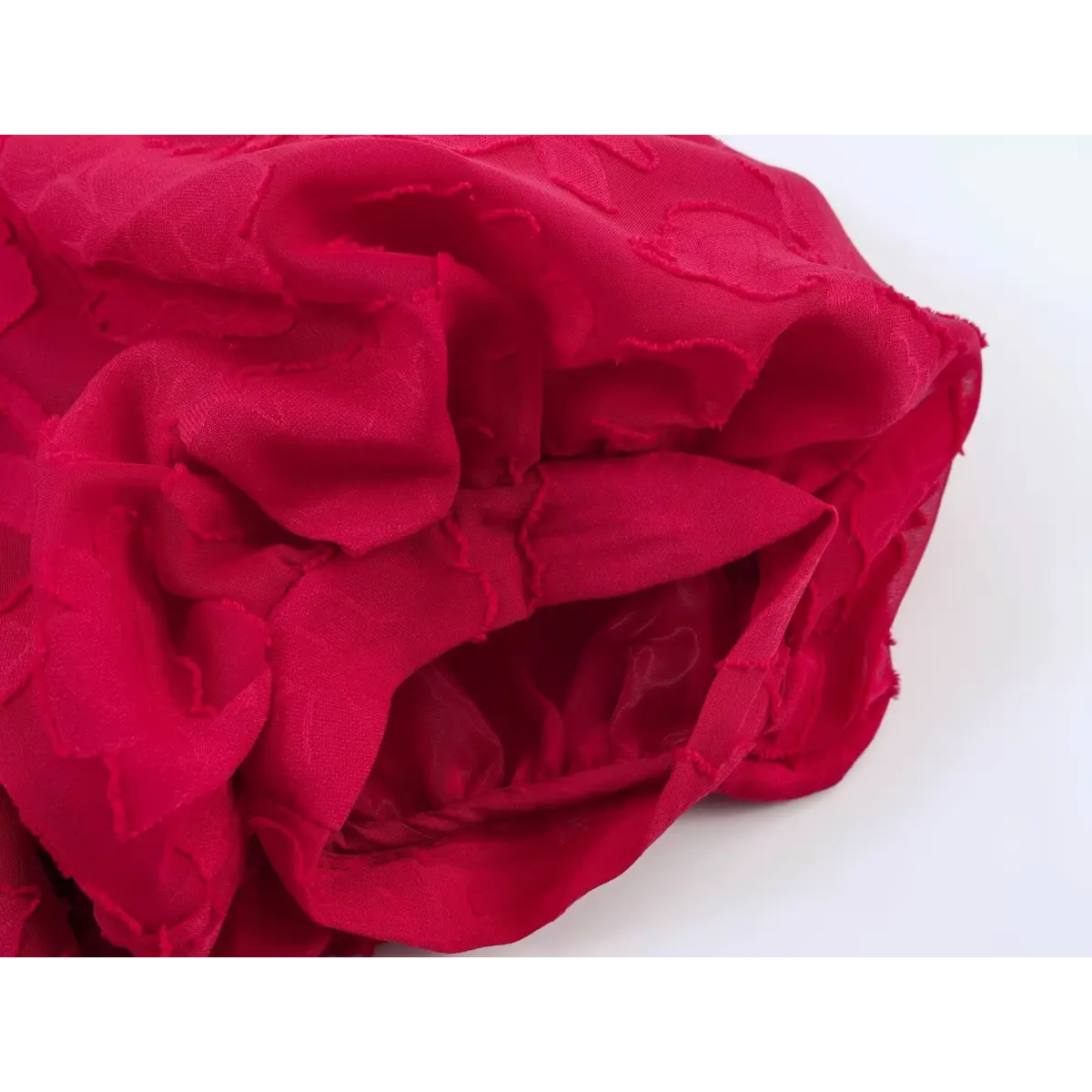 Close-up of the puff sleeve lining and gathered fabric on a red floral appliqu peplum top.
