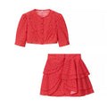 Flat lay of red ditsy floral two‑piece outfit, cropped puff sleeve top and ruffle tiered mini skirt