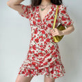 Model front view wearing red floral v-neck ruched mini dress, casual vacation outfit