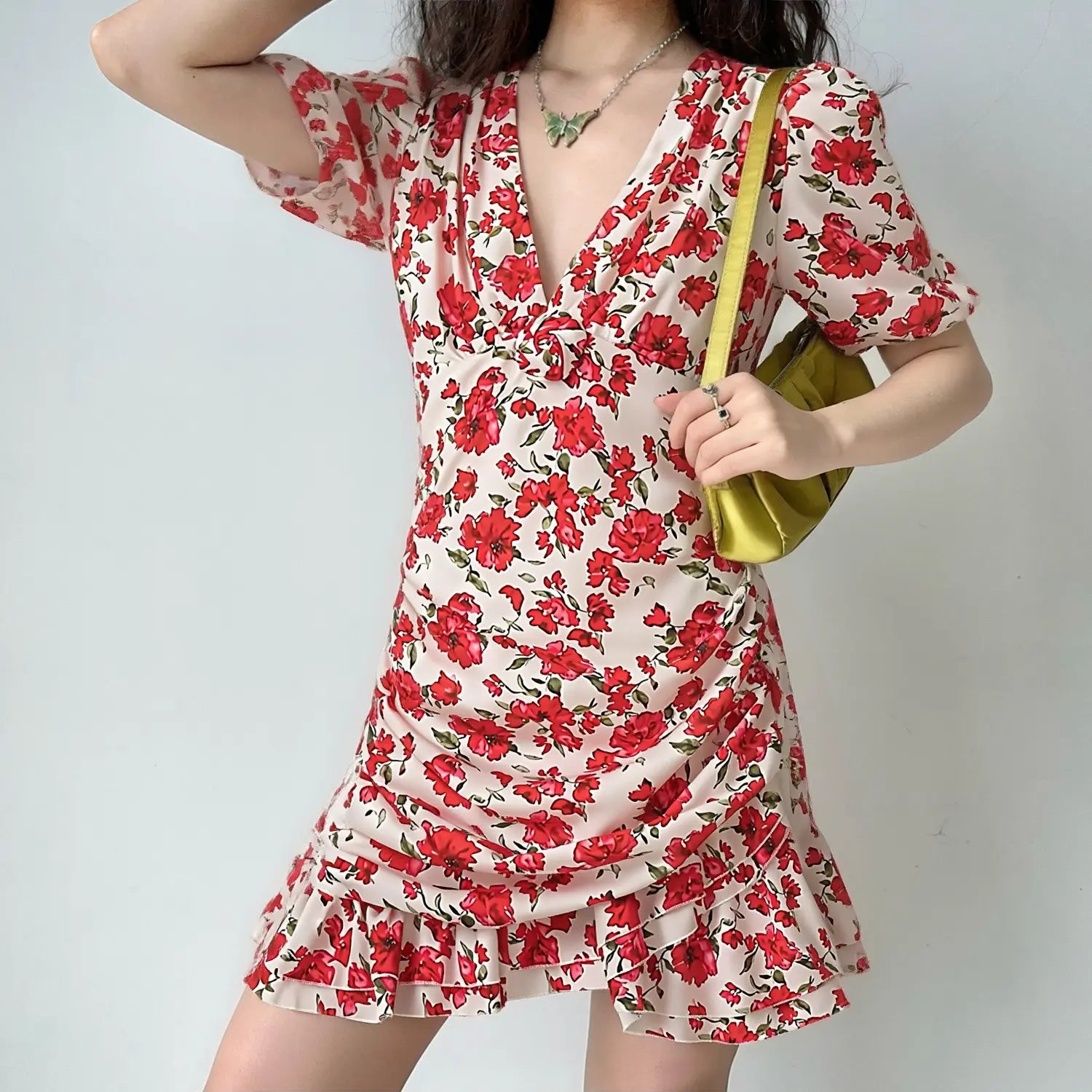 Model front view wearing red floral v-neck ruched mini dress, casual vacation outfit