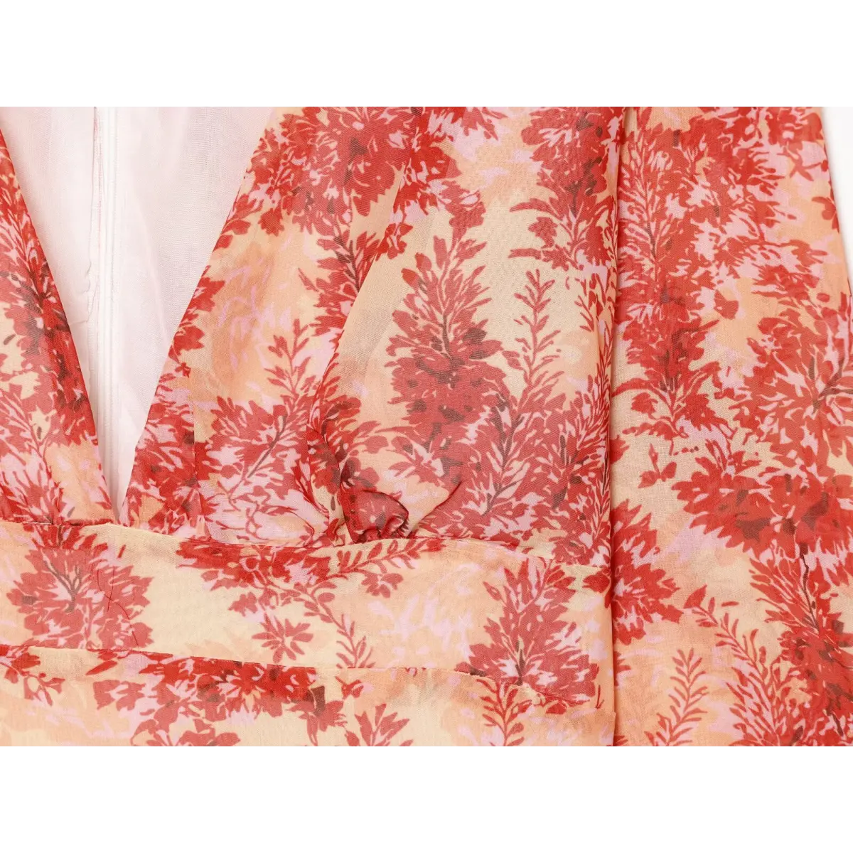 Close-up of the deep V-neckline and floral print on the red wrap dress