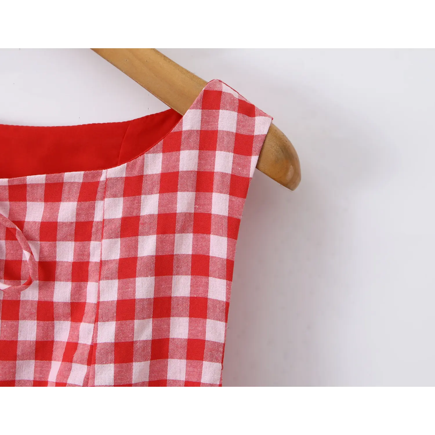 Close‑up sleeveless shoulder armhole seam red white gingham woven fabric texture