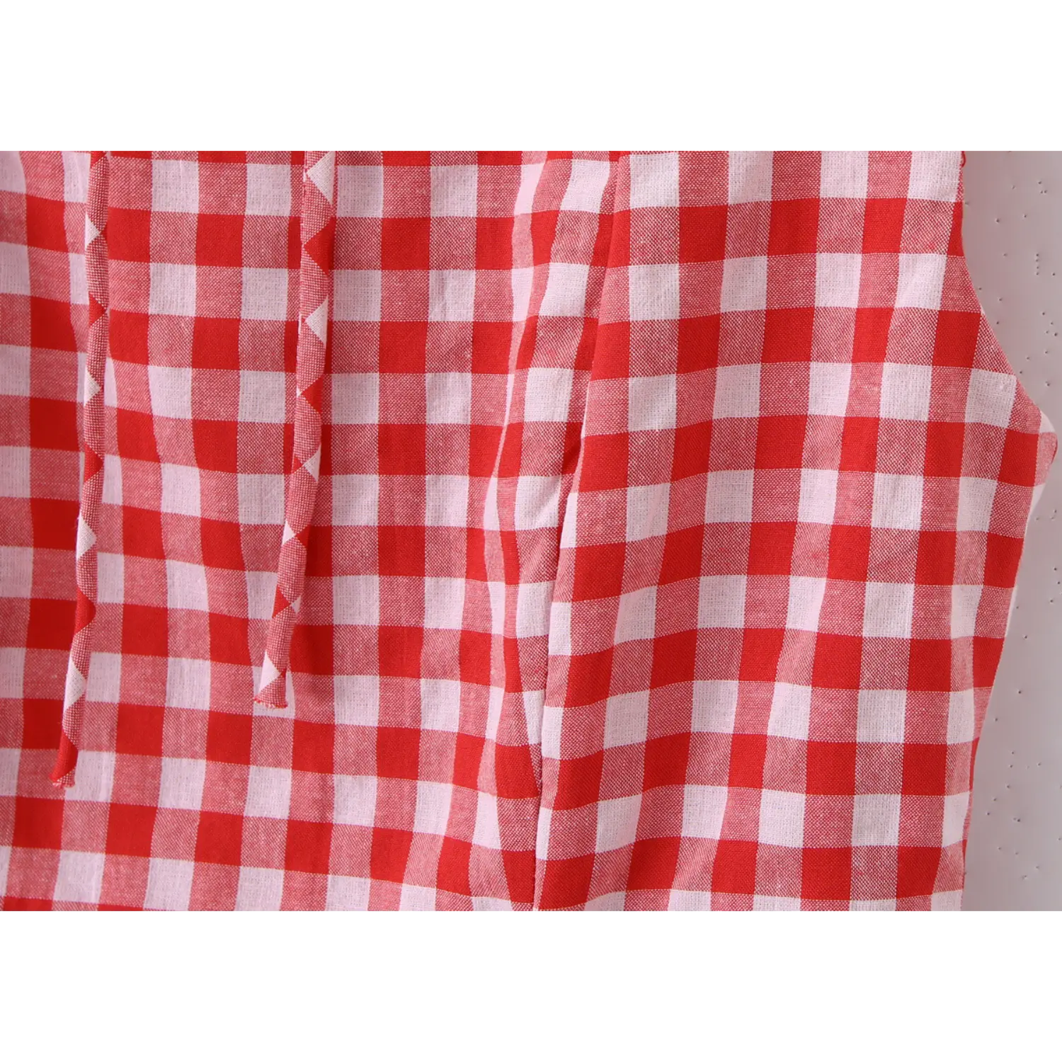 Extreme close‑up bodice stitching red gingham check woven fabric texture