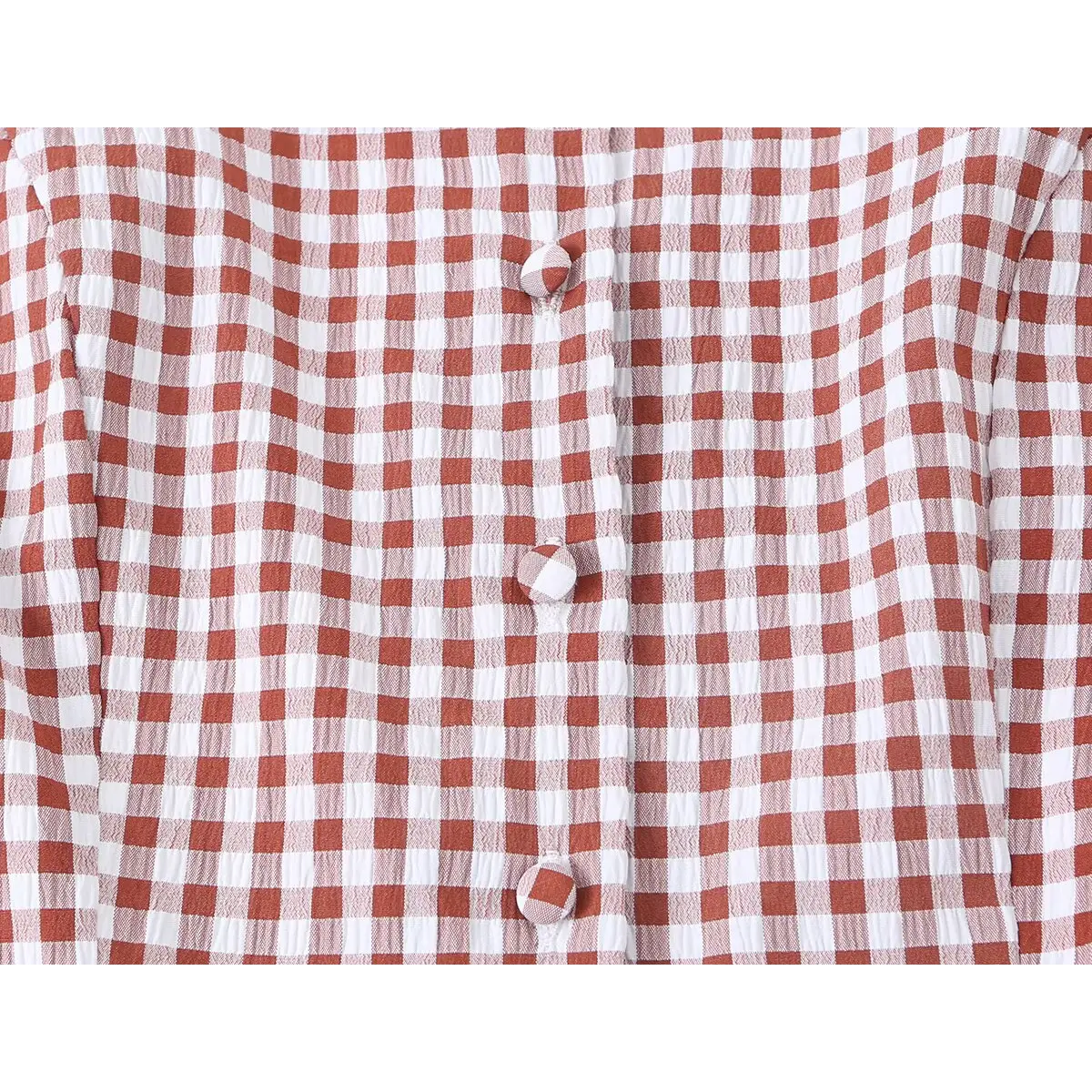 Close-up of the front button placket and gingham fabric texture on the red dress