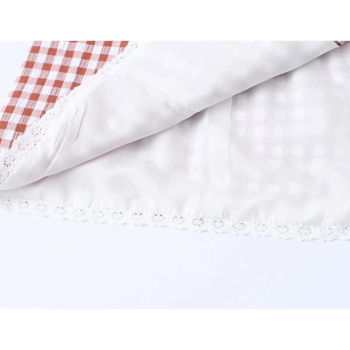 Close-up of the inner lining and lace-trimmed hem on the red gingham dress
