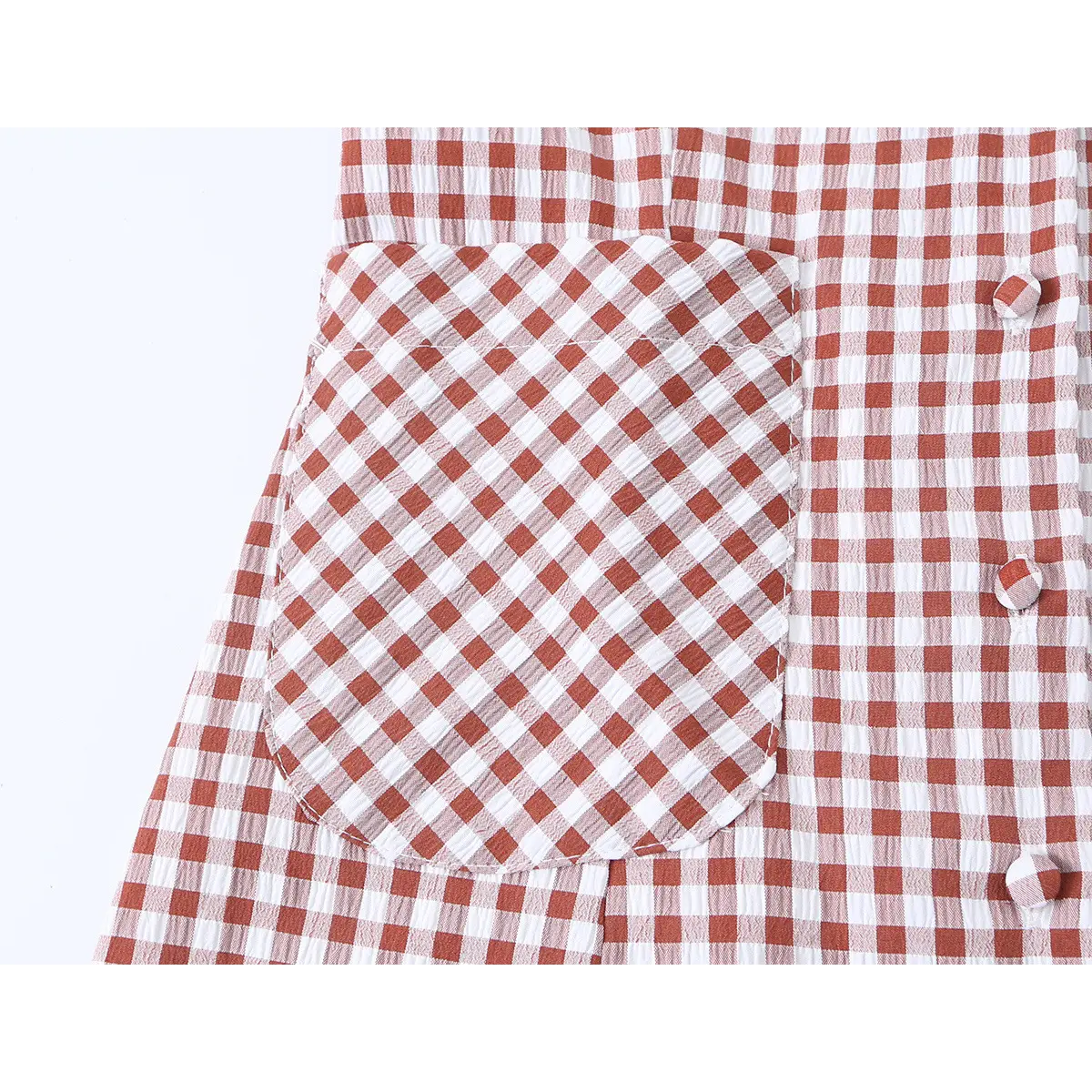 Close-up of the front patch pocket and red gingham pattern on the dress