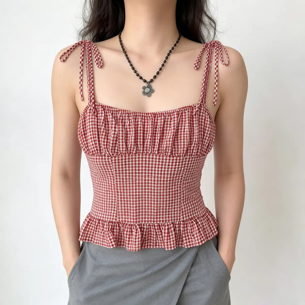 Front view of the red and white gingham cami top, showing the gathered bust and ruffled hem.