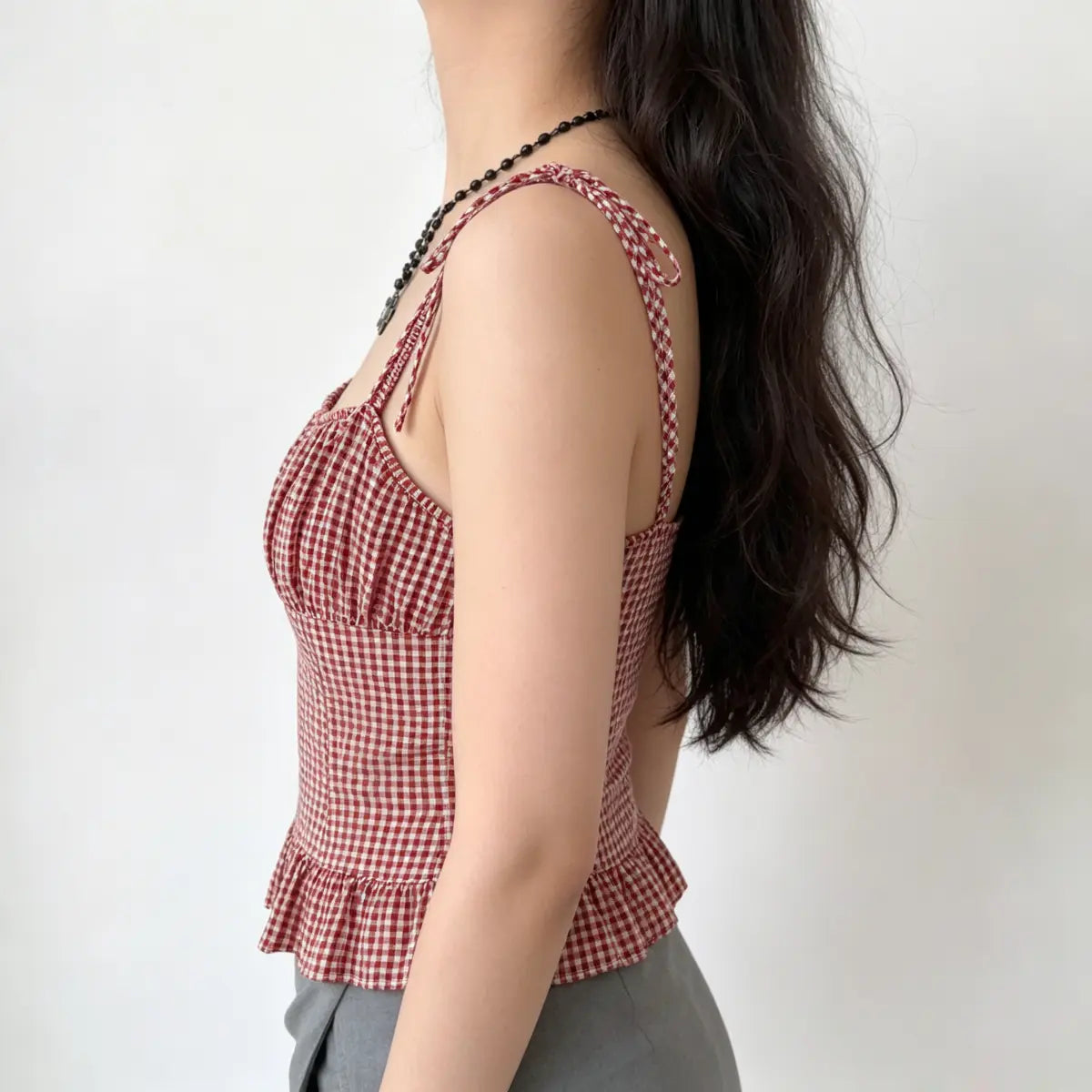Side view of the red gingham cami top, highlighting the tie straps and fitted silhouette.
