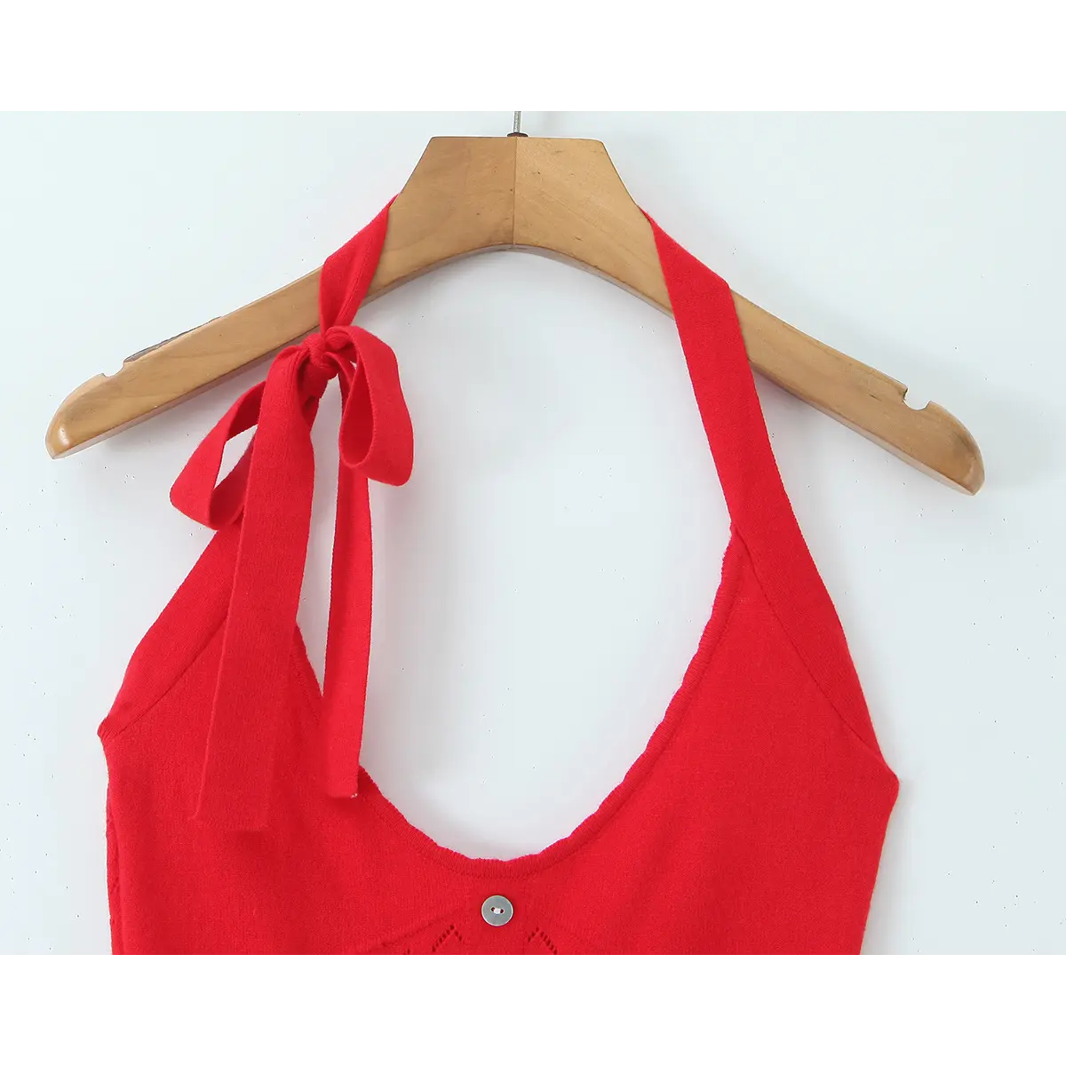 Back strap close-up of adjustable knotted halter tie on scarlet openwork knit mini dress.