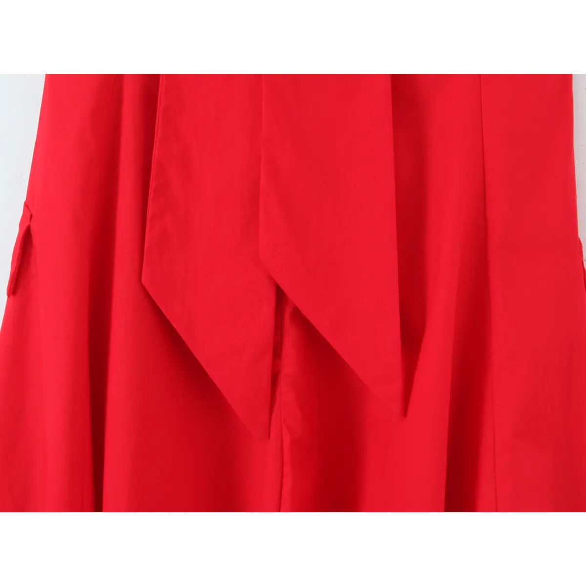  Close-up of the back of a bright red halter maxi dress, showing the long hanging tie and decorative pocket flaps.