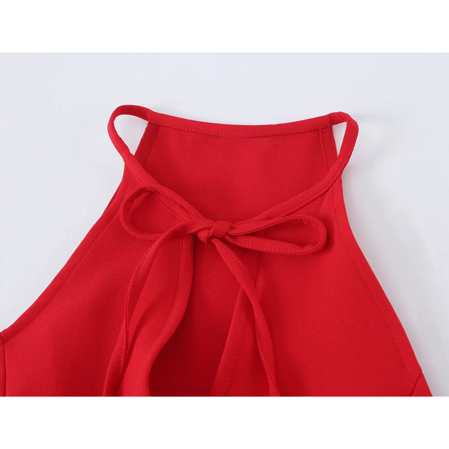 Close‑up of halter neckline fabric bow tie, keyhole opening detail on red peplum top