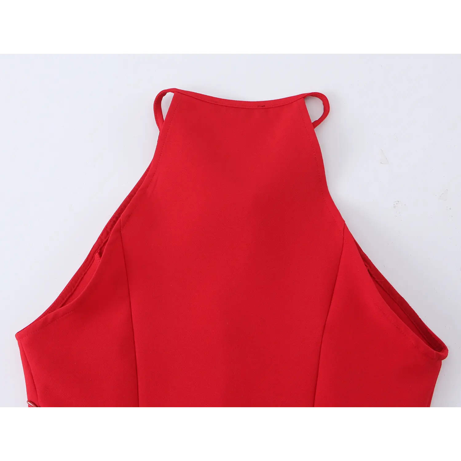 Close‑up fabric texture and double‑stitched hem edge of red halter peplum blouse