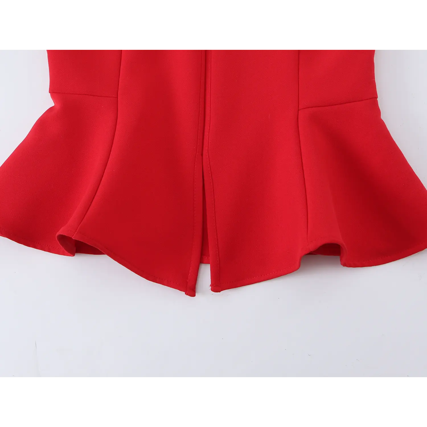 Close‑up view of front split peplum hem, structured stitching detail on red halter peplum top