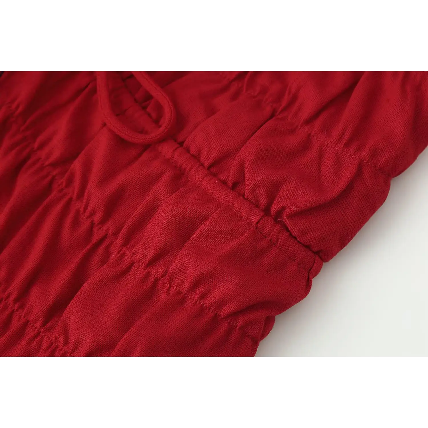 Macro shot of red halter top ruched gathered fabric texture and stitching detail