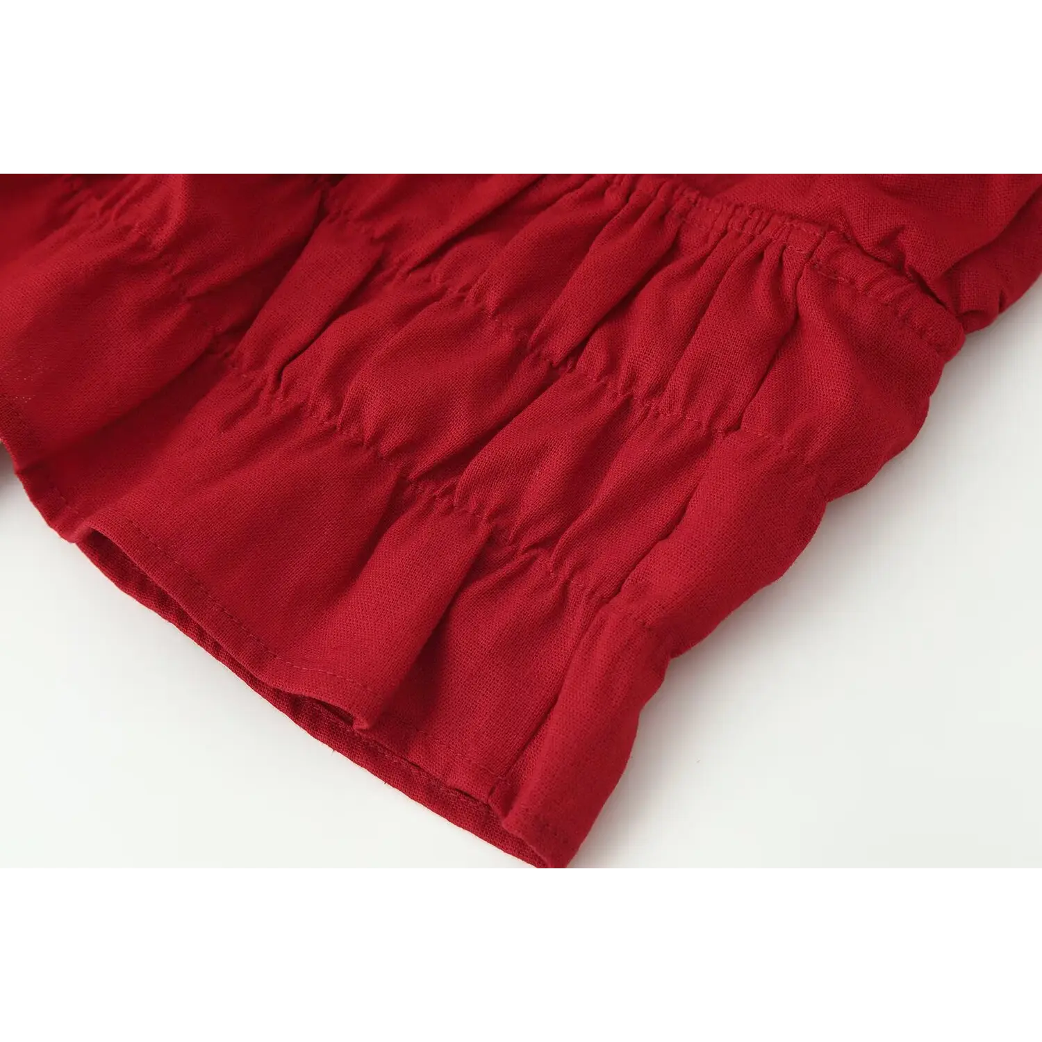 Close‑up of red halter crop top flared ruffle hem edge and sewing workmanship