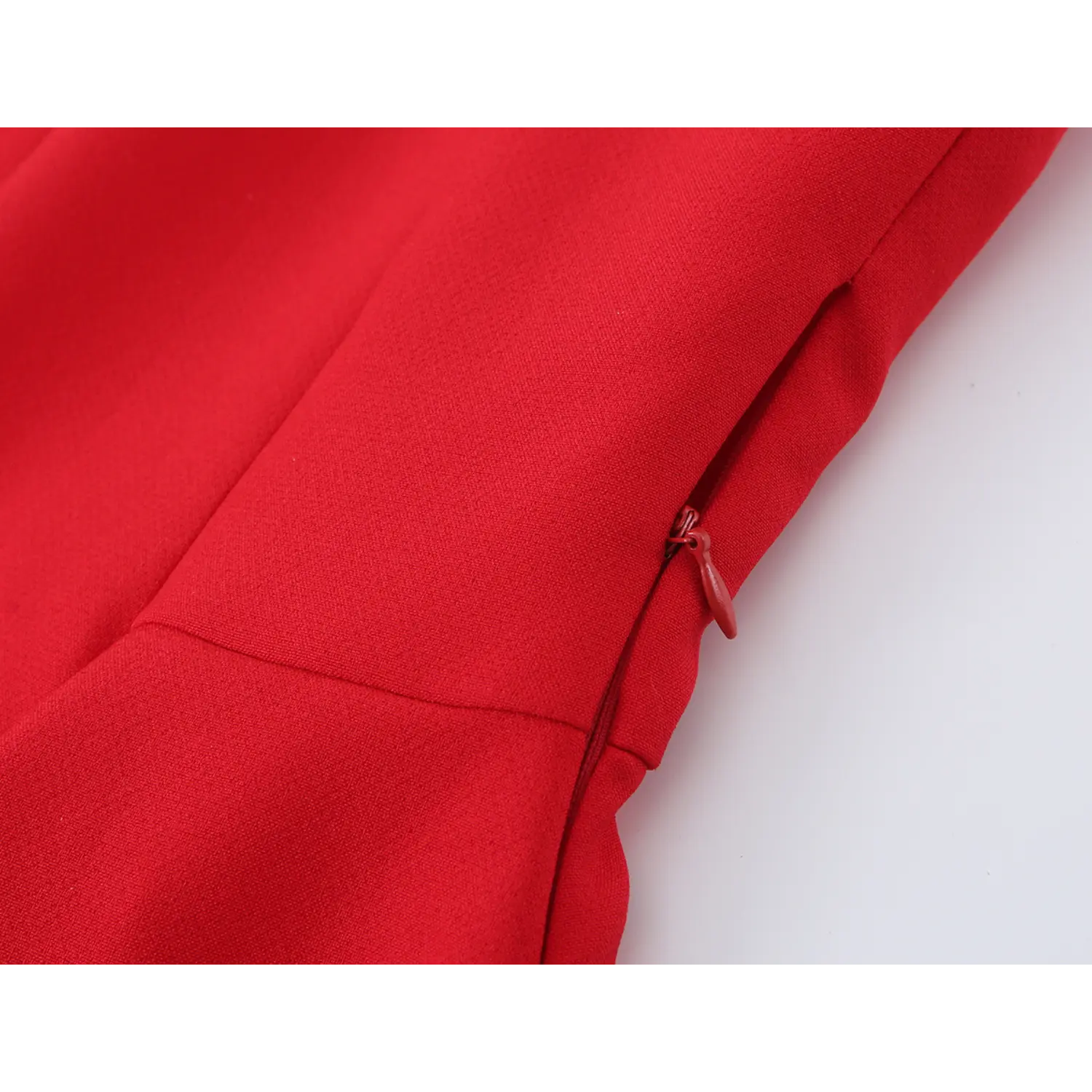 Close‑up of invisible side zipper on red halter peplum top, textured woven fabric detail