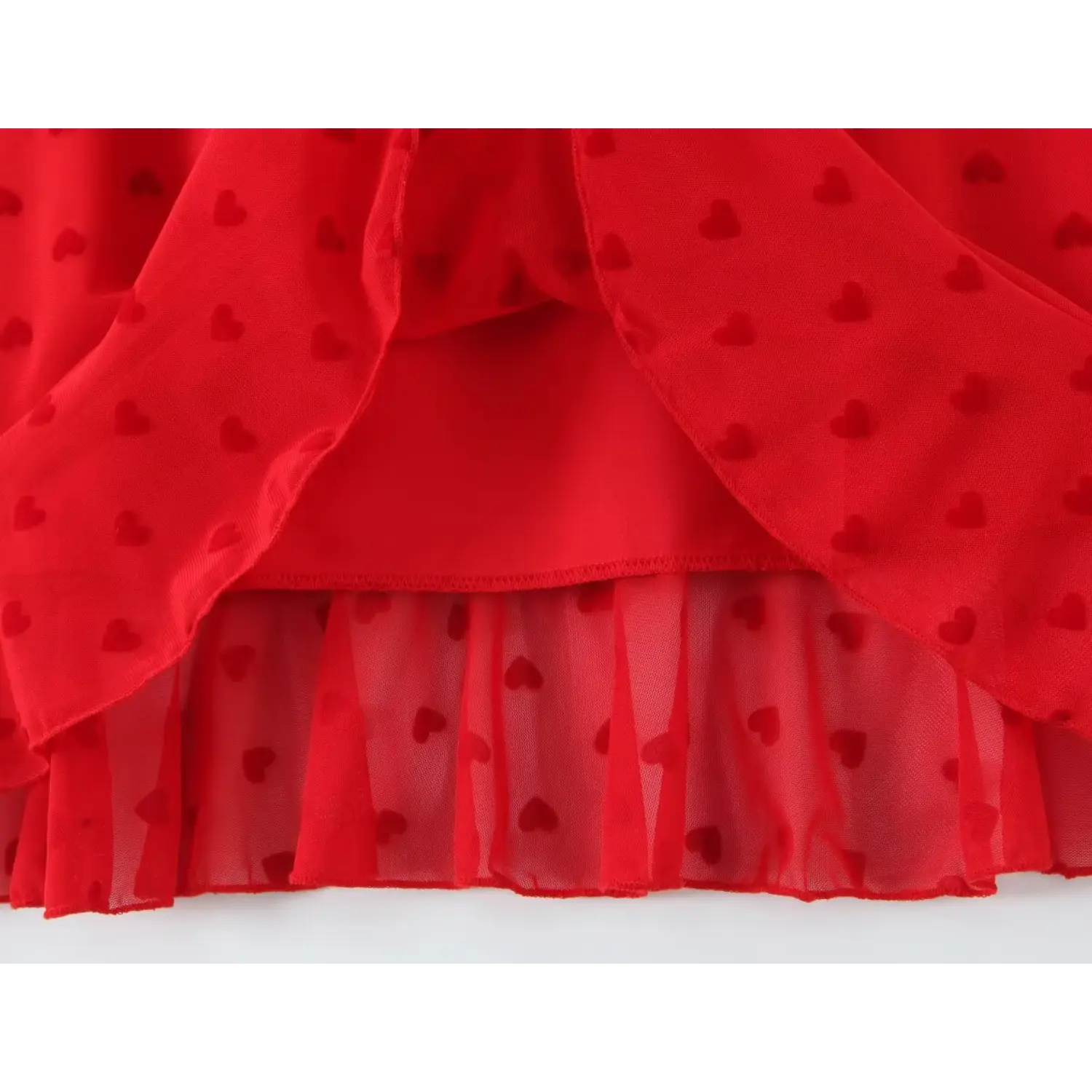 Close‑up inner lining and double‑layer ruffle hem construction red flocked heart mesh dress