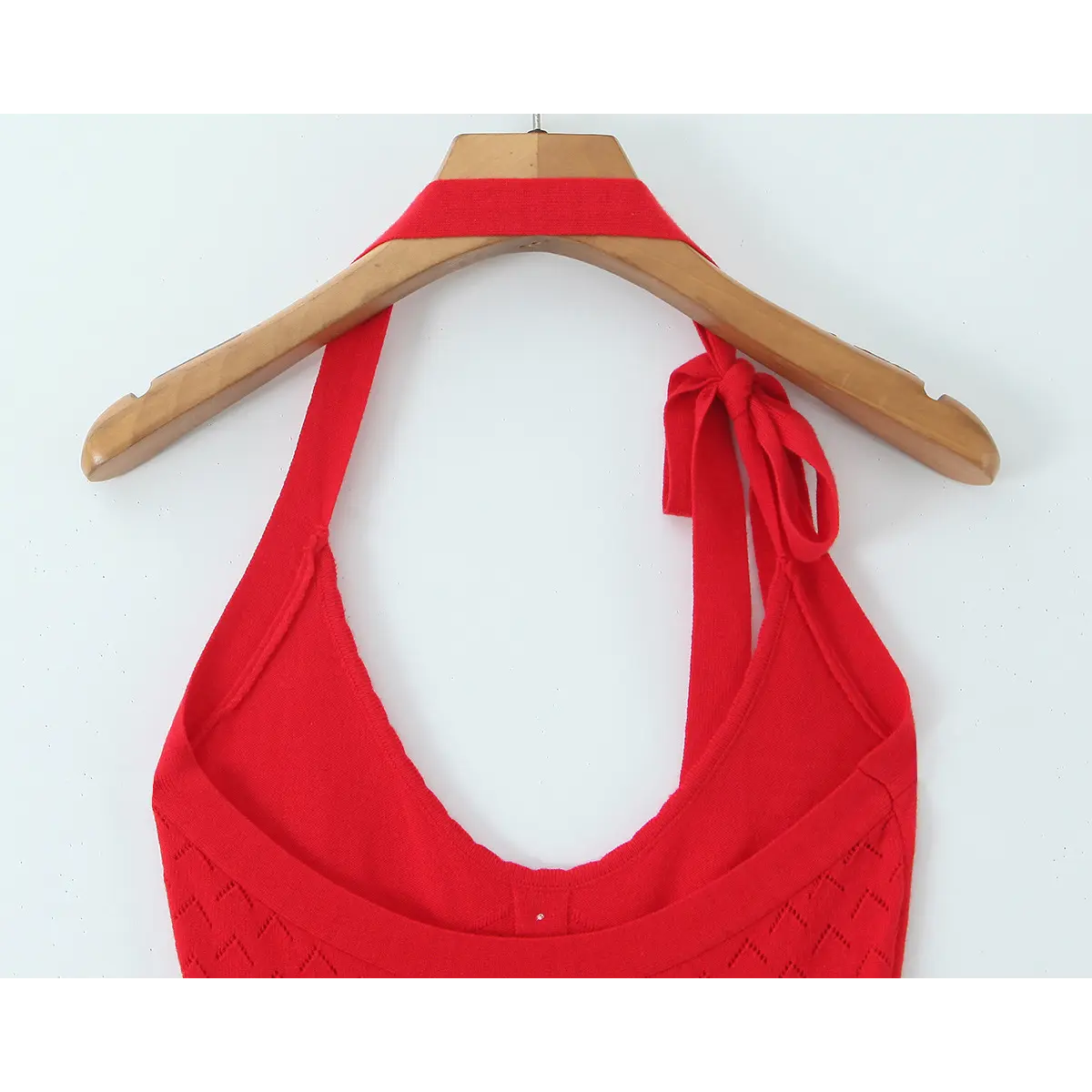 Inner back neck close of U-back red knit halter mini dress, scalloped raw edge neckline construction.