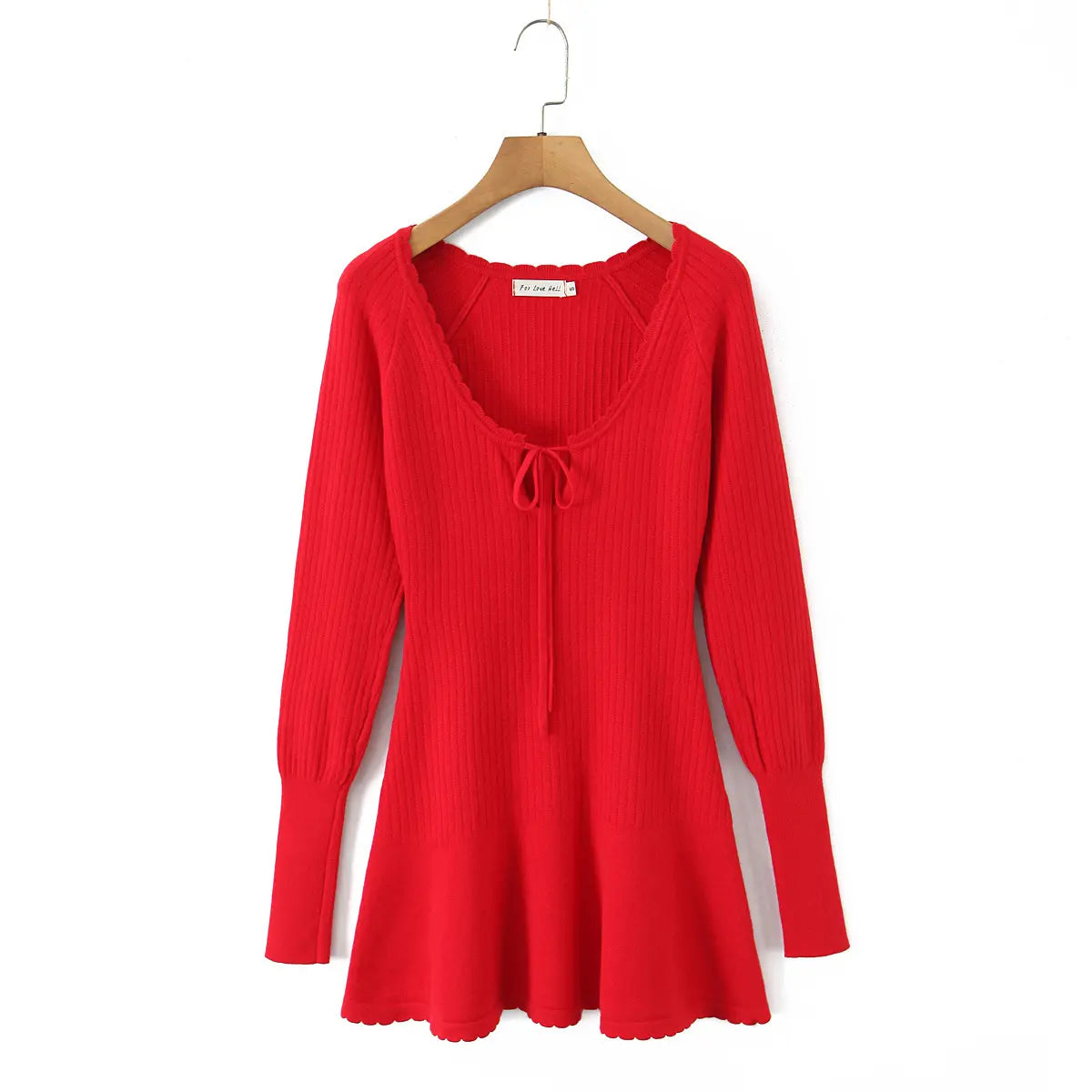 Full front view of the red knit mini dress on a wooden hanger.