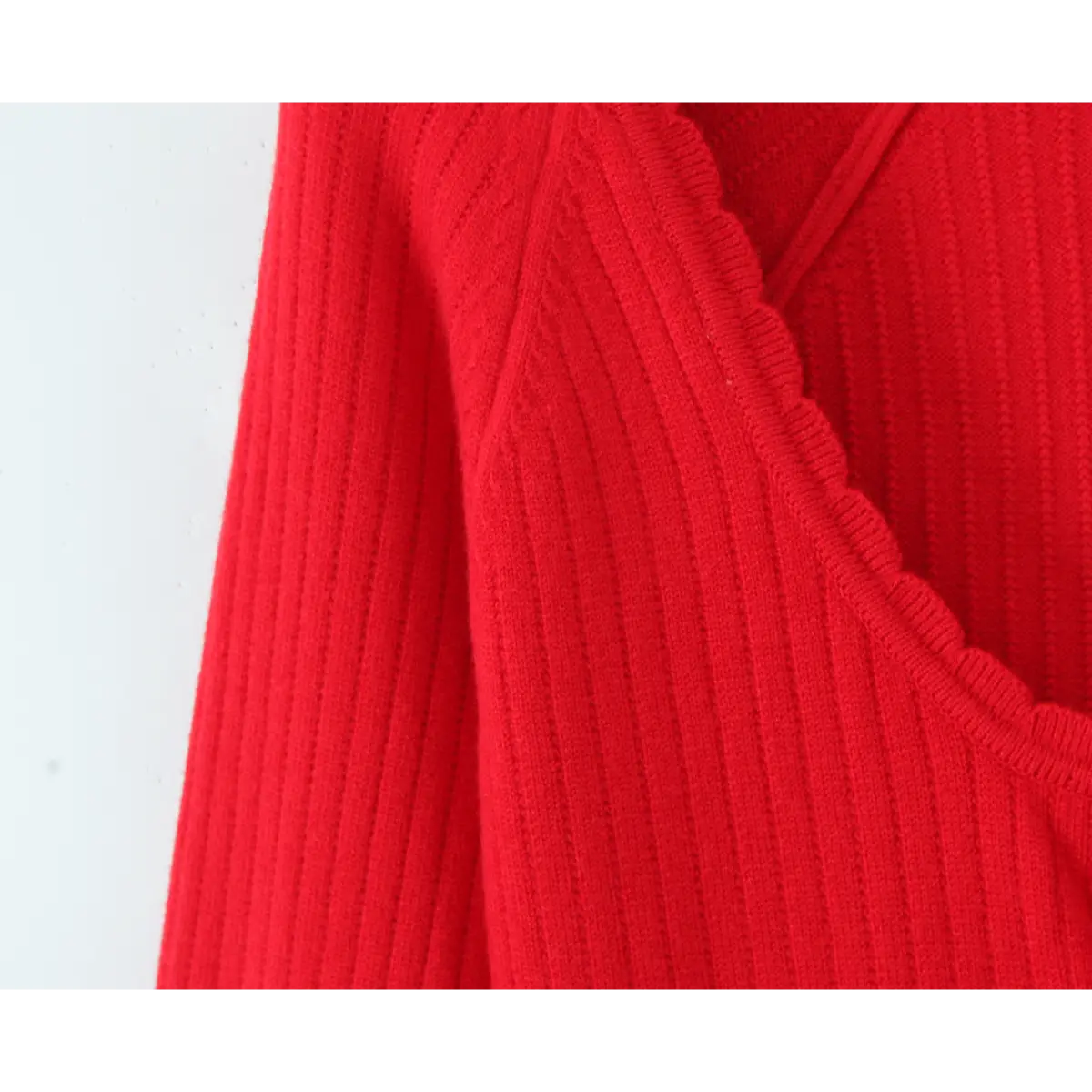 Close-up of the scalloped neckline and ribbed knit texture on the red dress.