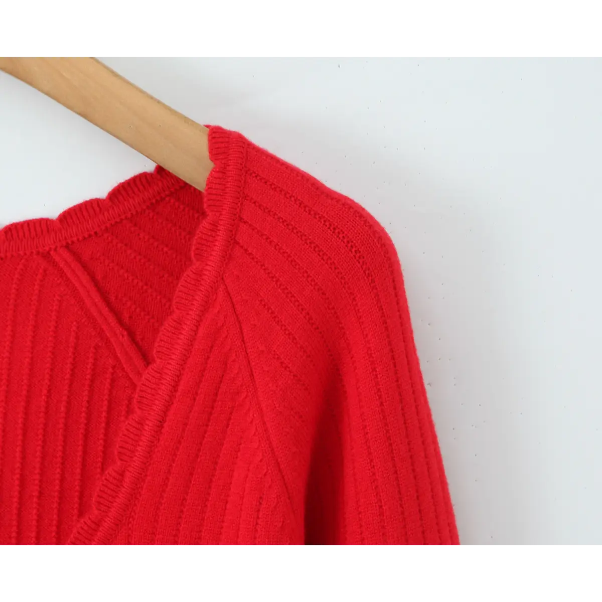 Close-up of the shoulder seam and neckline construction on the red knit dress.
