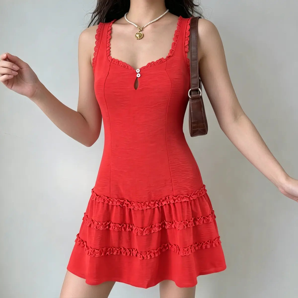  Full front view of a model wearing a red lace-trim tiered mini dress, showing the keyhole neckline and ruffled tiers.