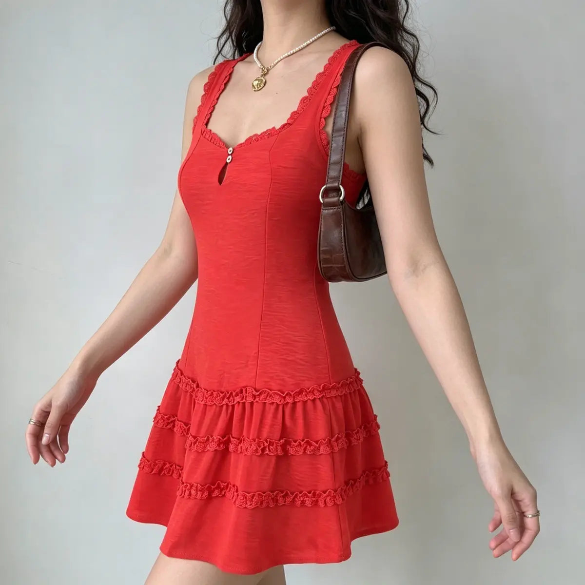 Profile view of a model in a red lace-trim tiered mini dress, highlighting the fitted silhouette and lace trim.