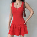 Model wearing a red lace-trimmed cami mini dress, showcasing the square neckline, keyhole cutout, and tiered lace skirt.