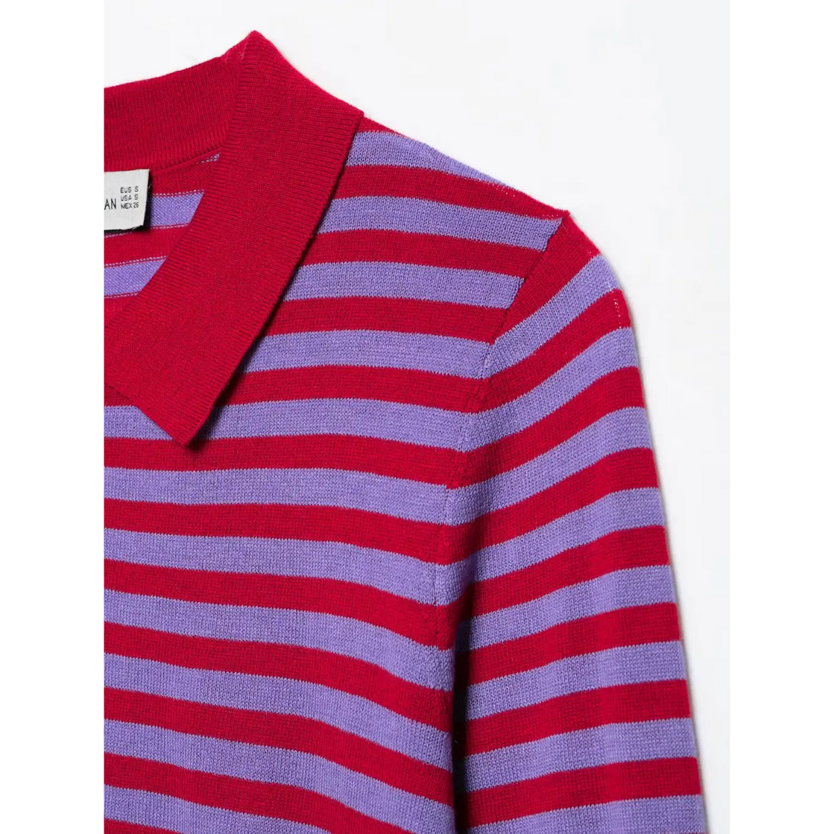 Close-up of white size label inside collar of striped knit top with regional size info