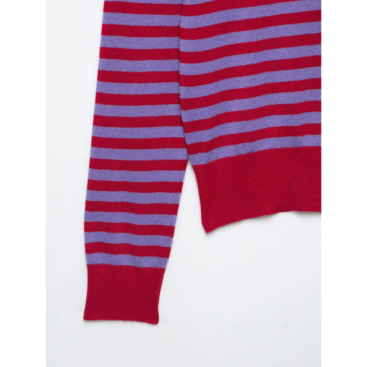 Close-up of long striped sleeve and red ribbed cuff and hem on knit top
