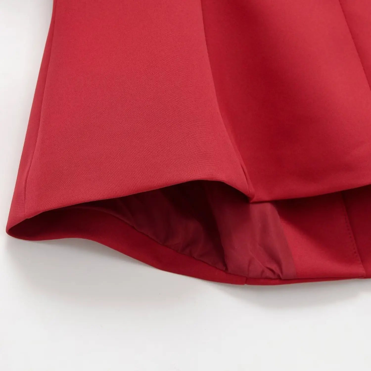 Closeup of red new chinese top hem, showing inner lining and fine stitching