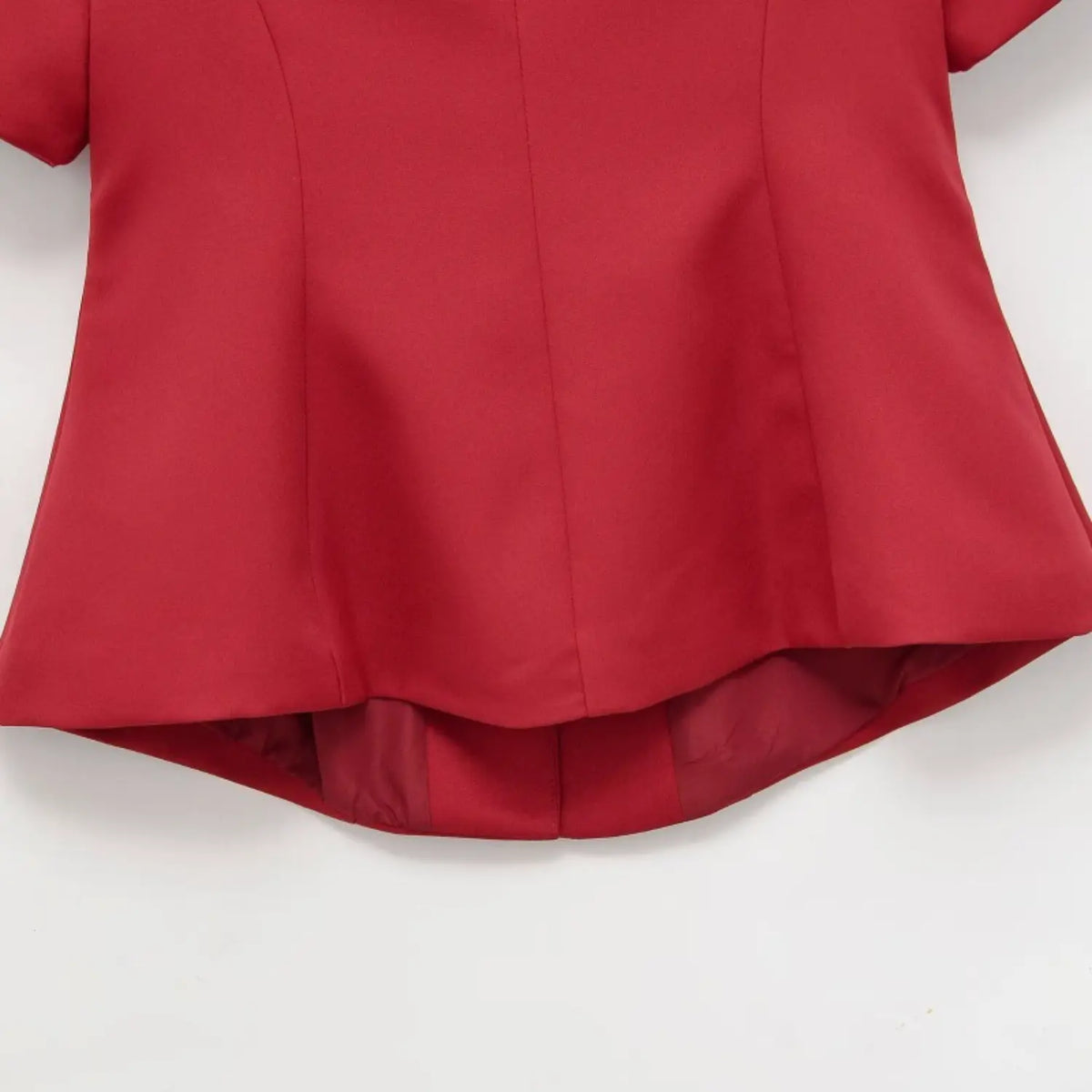Back lower detail of red new chinese top, curved peplum hem and inner lining showing