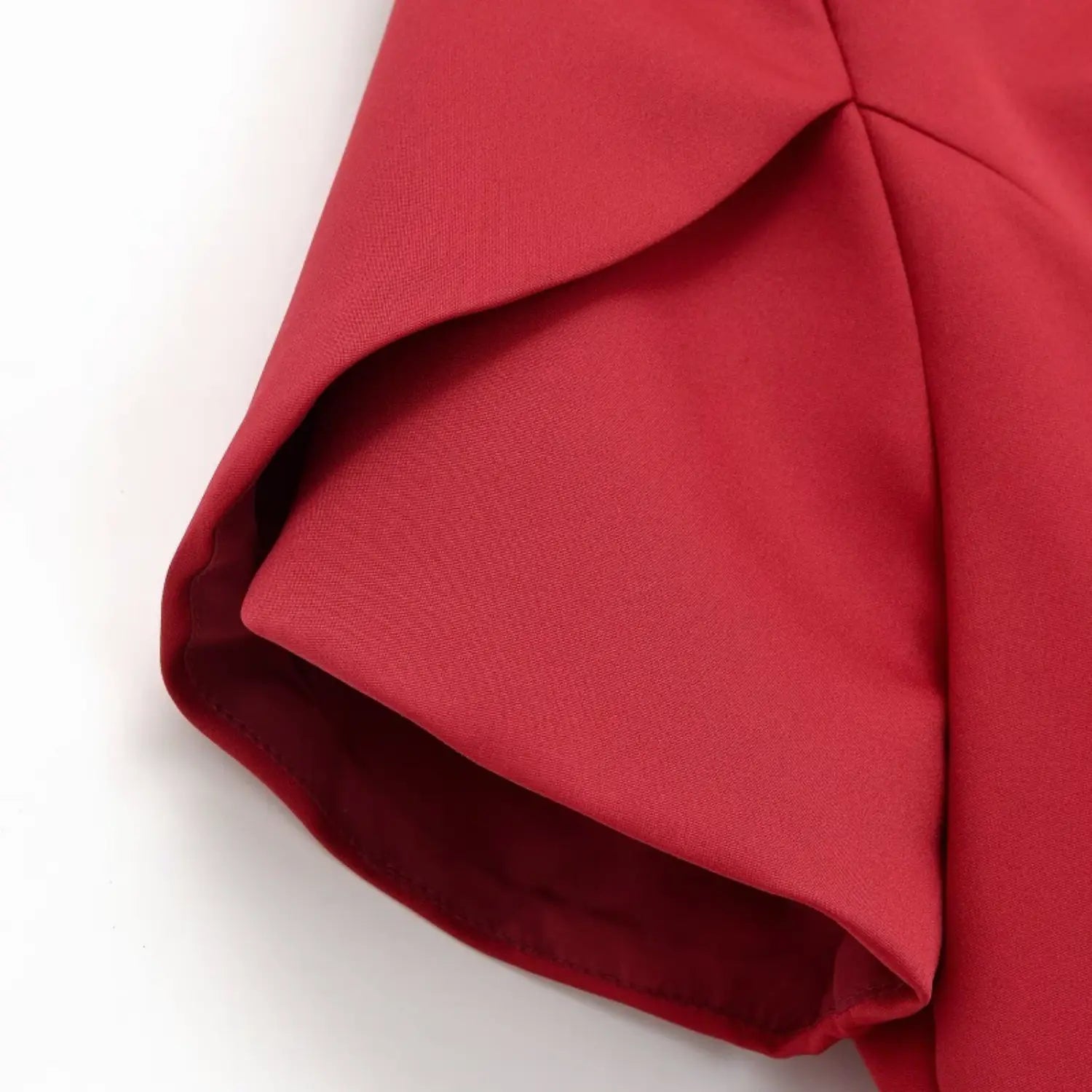 Close-up of folded short sleeve fabric, smooth woven material and inner lining of red chinese style blouse
