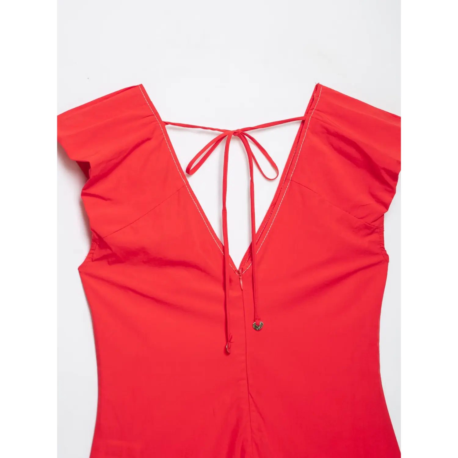 Close-up back view of red V-neck blouse, self tie string and metal charm details
