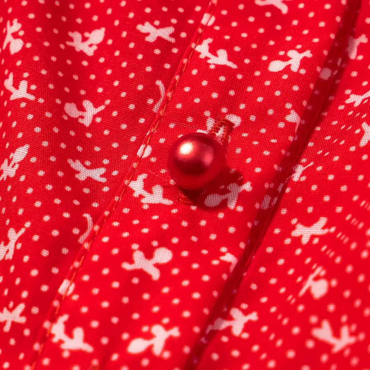 Close‑up shot of red pearl button on red ditsy floral cropped top