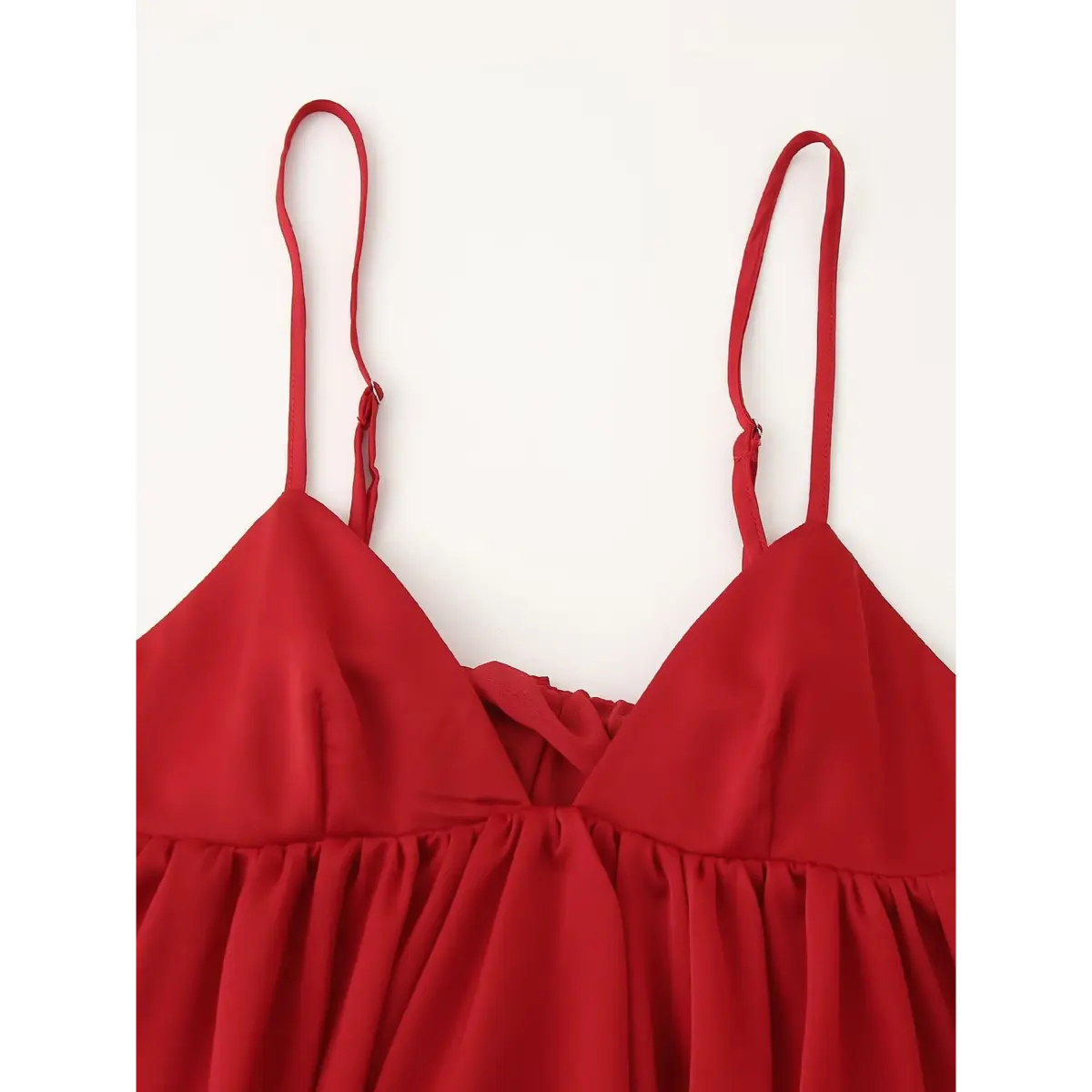 Full view of the red peplum cami top, featuring thin adjustable straps, V-neckline, and gathered peplum hem