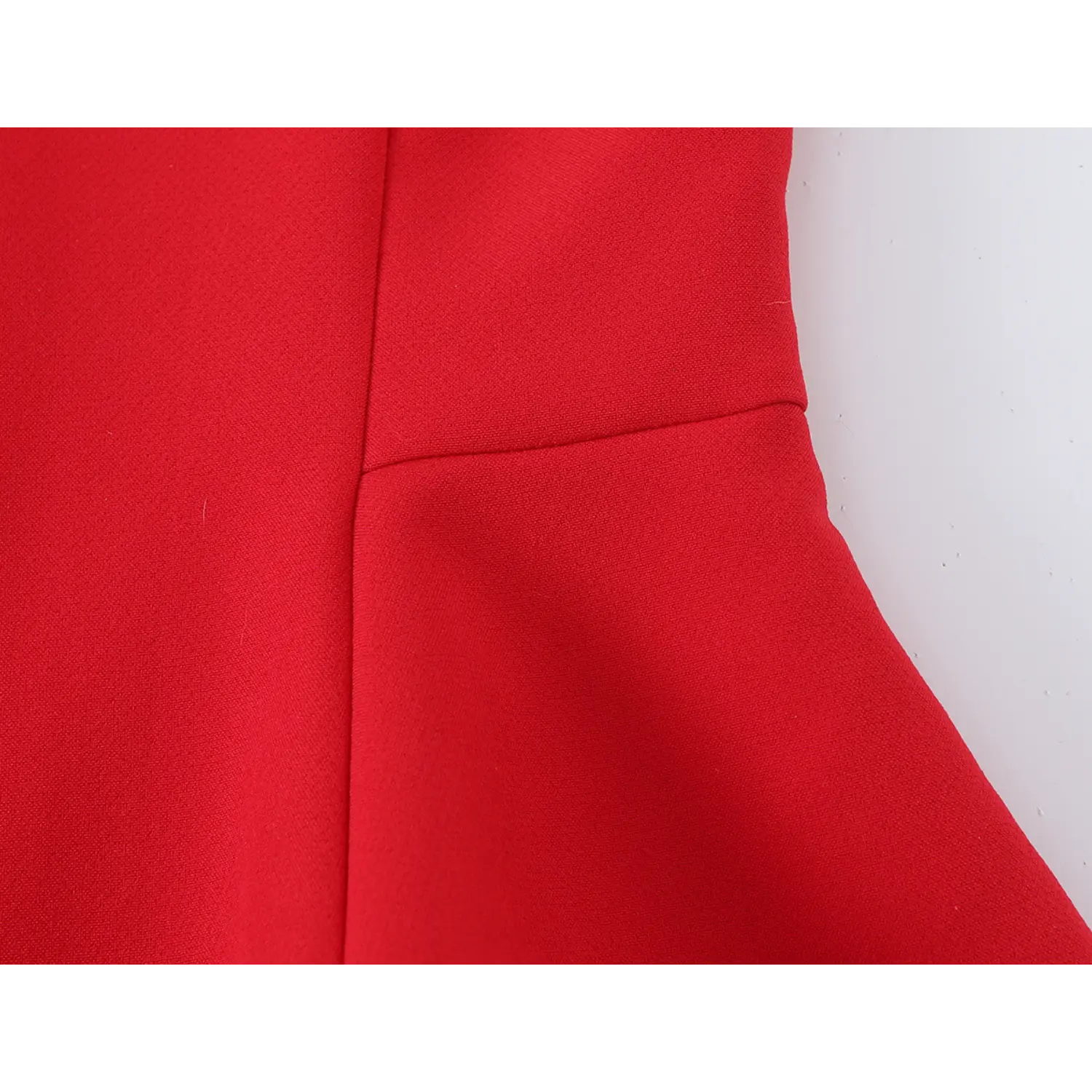 Close‑up of waist seam transition from fitted bodice to flared peplum panel