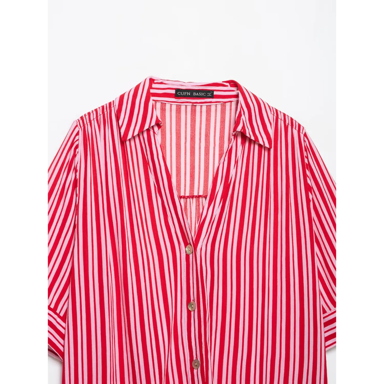 Partial close-up of lapel notched V-neck, natural shell buttons and vertical stripe woven fabric