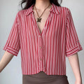 Front lifestyle shot on model of red pink vertical stripe cropped blouse, notched lapel collar, tab short sleeves, casual summer outfit