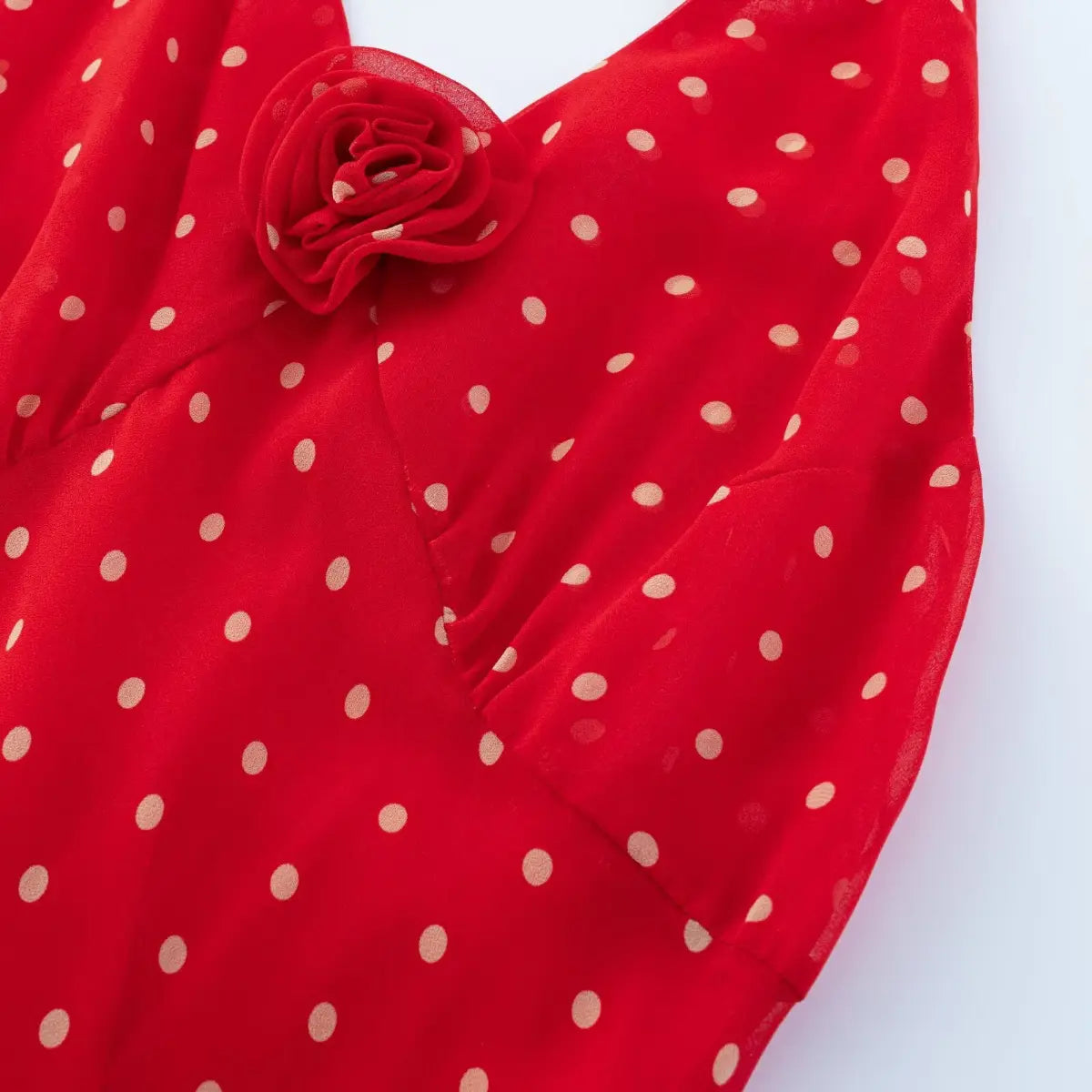 Close-up of layered ruffled hem on red white polka dot chiffon halter midi dress with full red lining.
