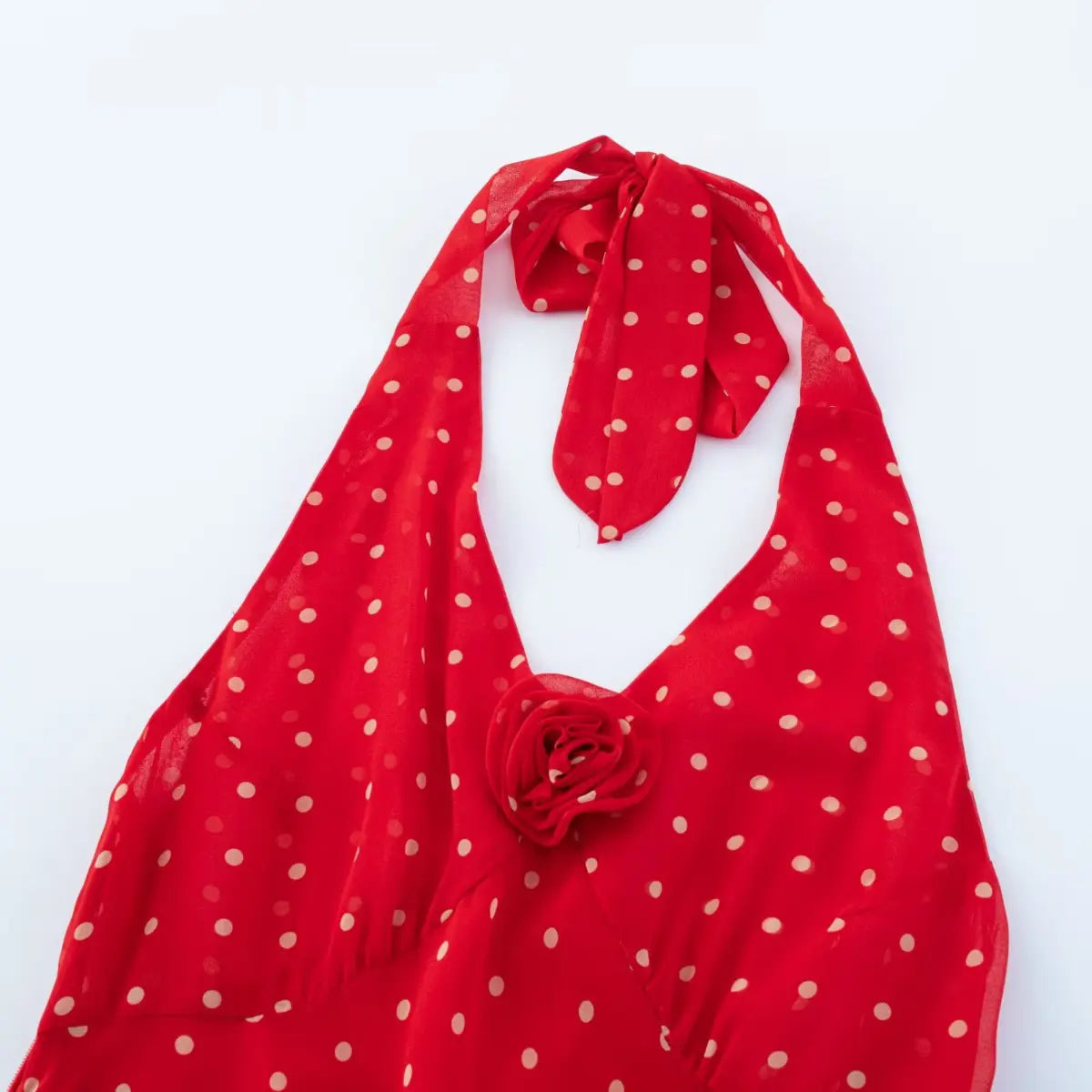 Macro close-up of handmade 3D chiffon rose appliqué at V-neck on red polka dot halter midi dress.