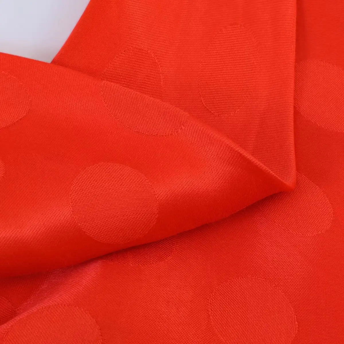 Close-up of the polka dot jacquard fabric texture on the red dress