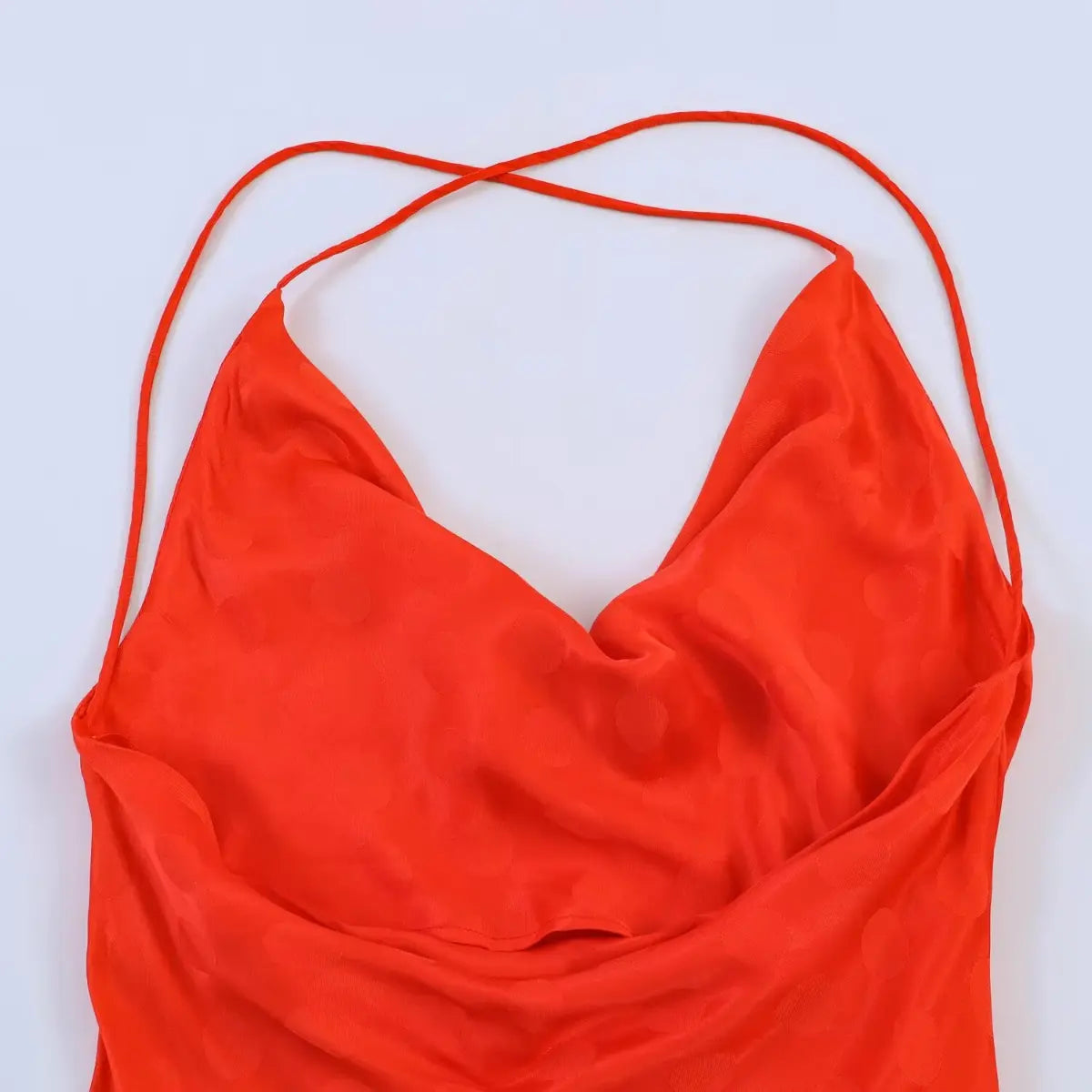 Full back view of the red polka dot jacquard dress, featuring the cowl neck and thin crisscross straps