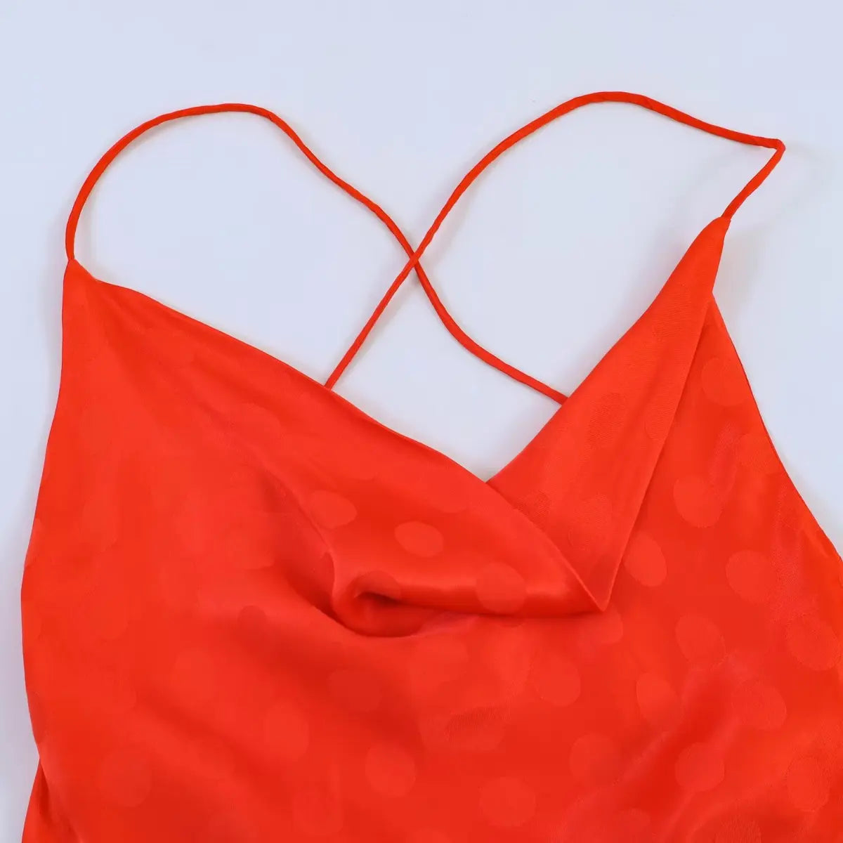Front view of the red polka dot jacquard dress, showing the cowl neck and crisscross straps